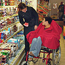 Frau mit Jungen im Rollstuhl im Supermarkt